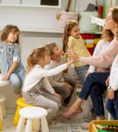 Kids at vacations care talking to teacher