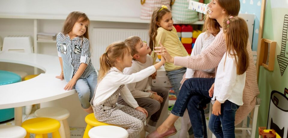 Kids at vacations care talking to teacher